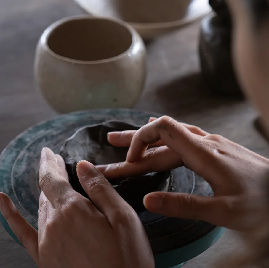 Hands shaping clay