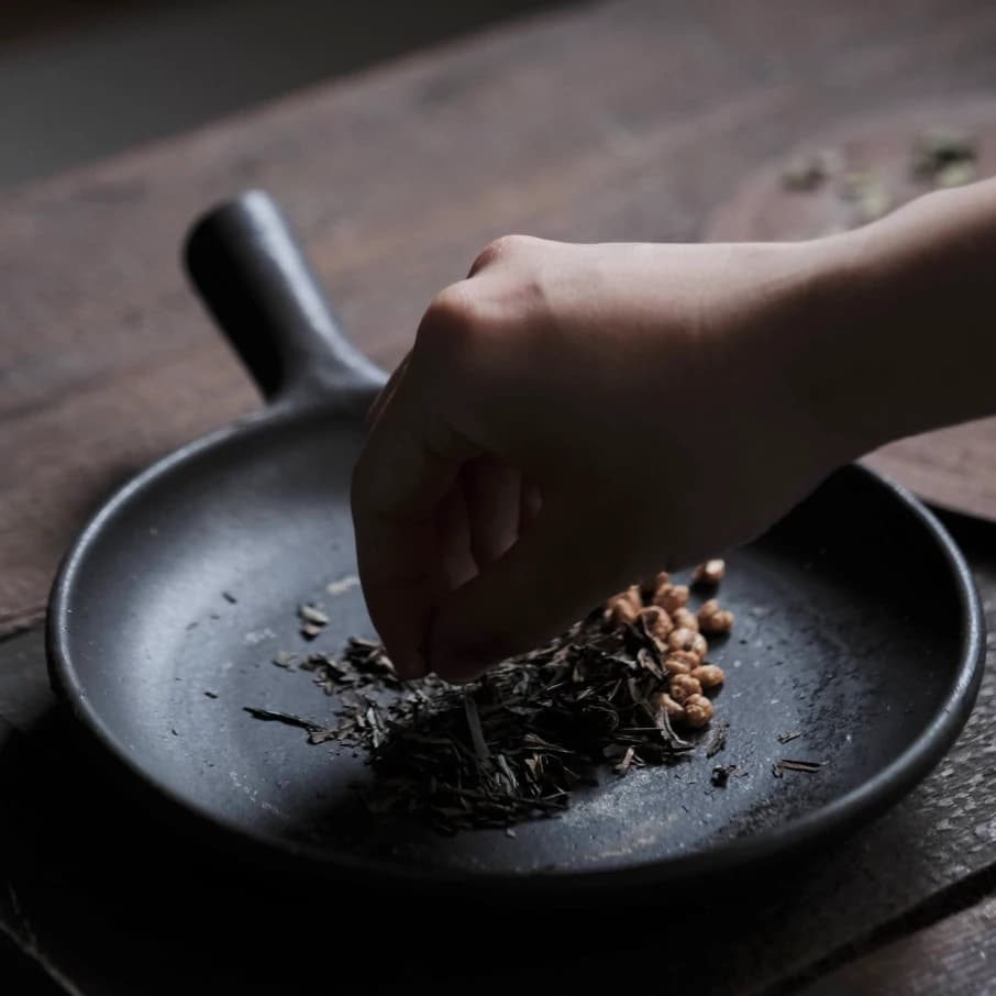 Traditional tea whisk and matcha powder in ceramic bowl