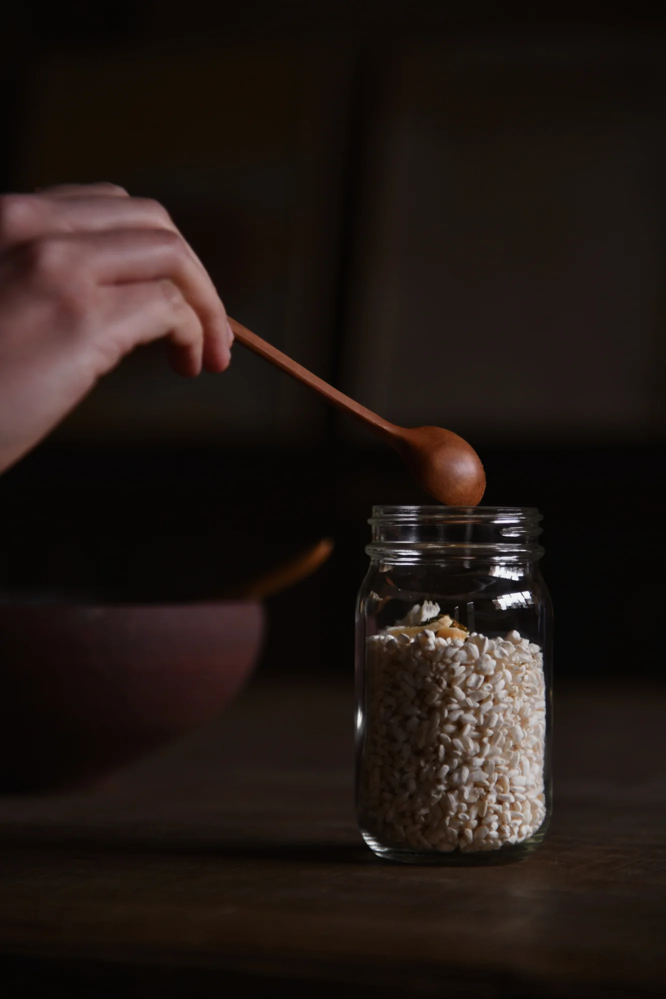 Chopsticks holding a pickled plum in a jar