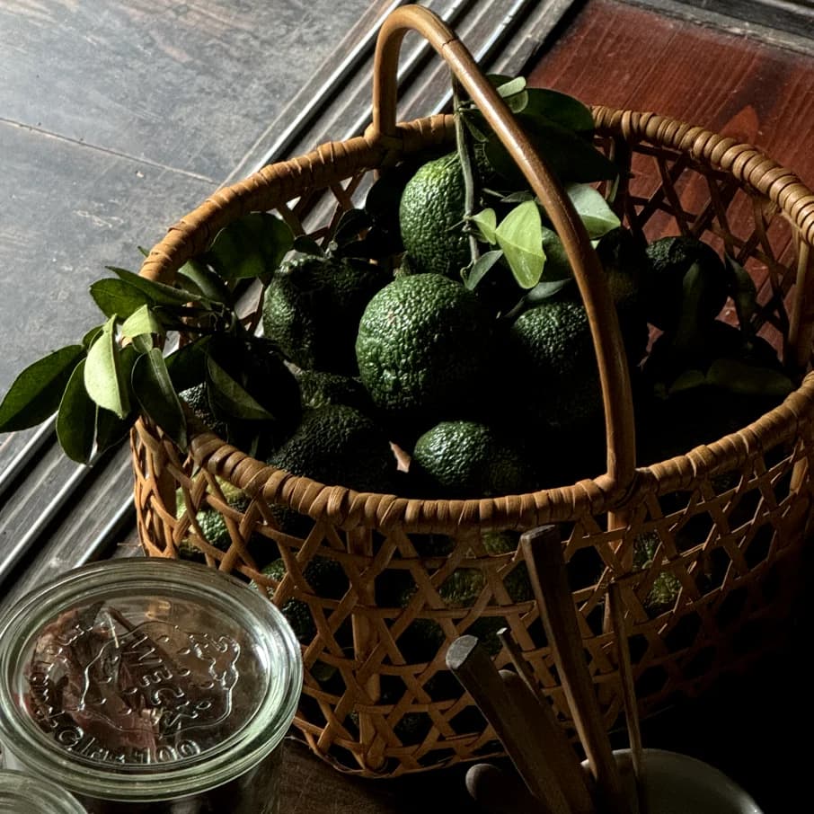 A basket of citrus fruits and a glass jar