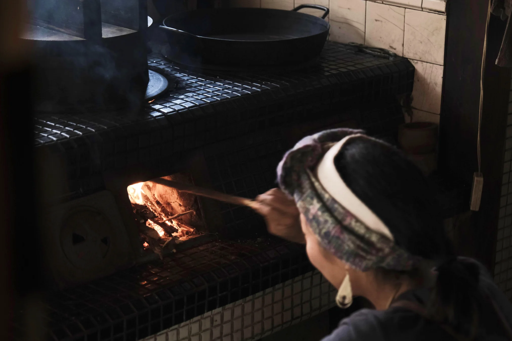 Person tending to a wood fire stove