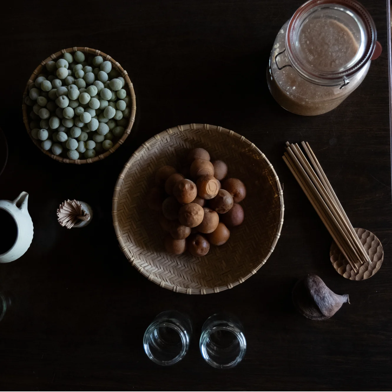 Bowls and jars with plums and other items for fermentation