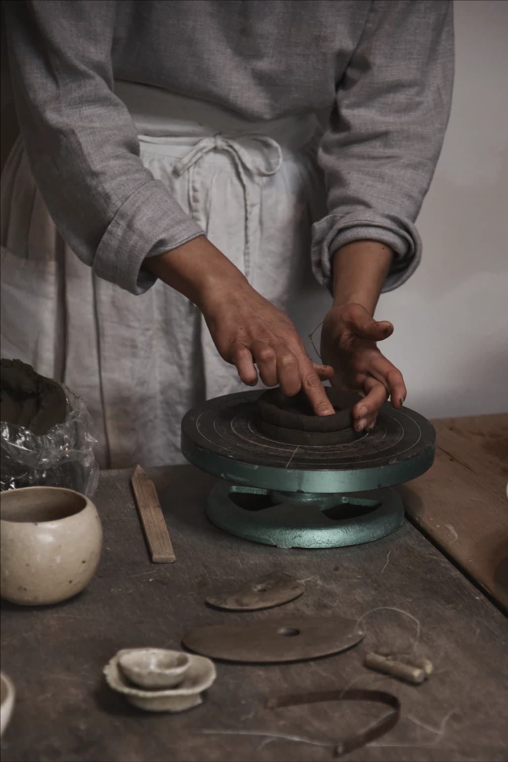 A potter working at a workstation