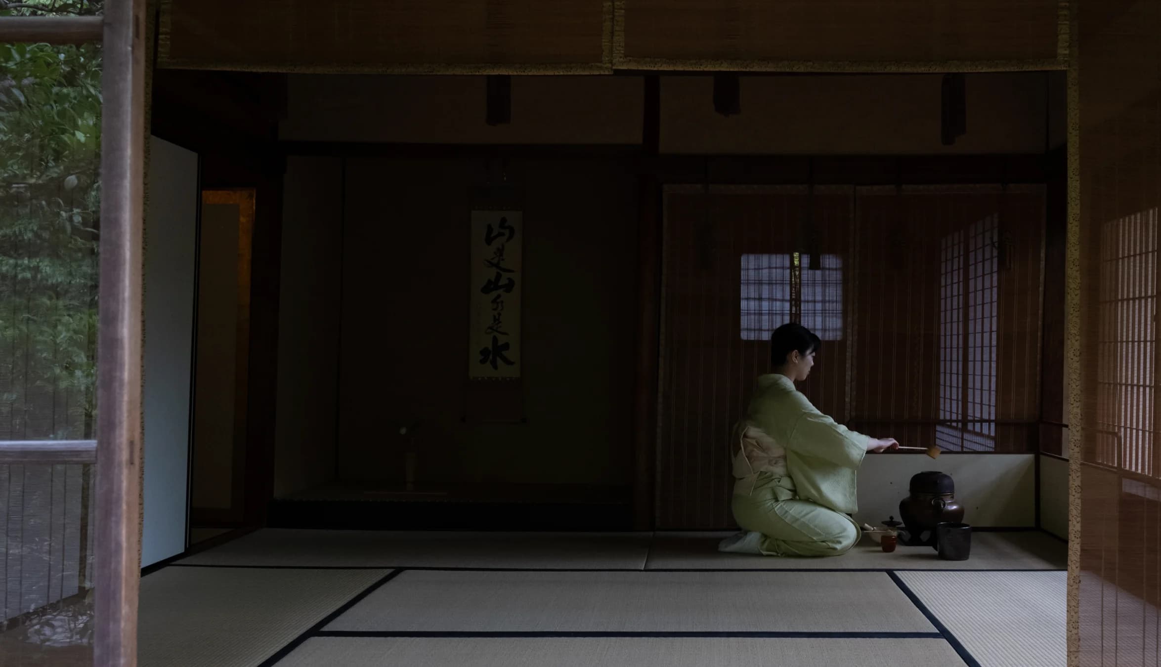 Woman in traditional Japanese clothing preparing tea