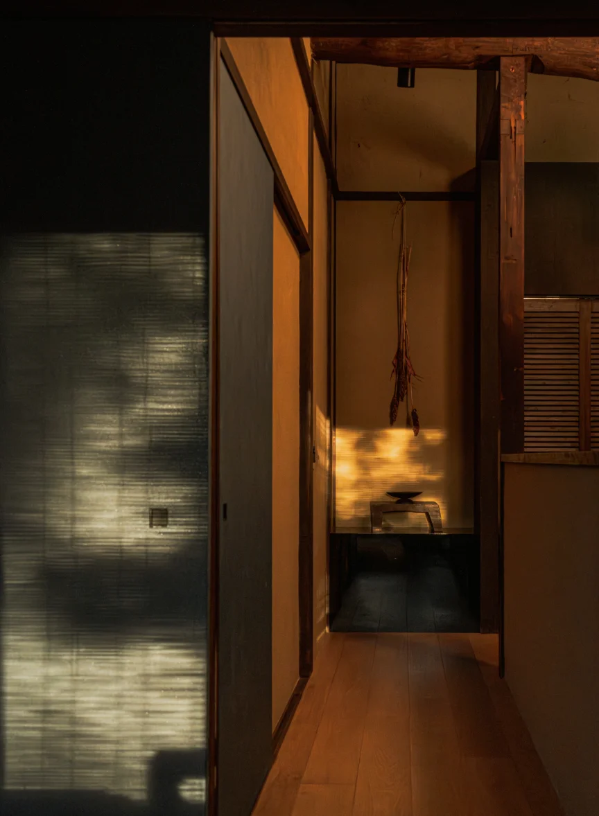 Hallway with tokonoma alcove, hanging dried flowers, and warm afternoon light