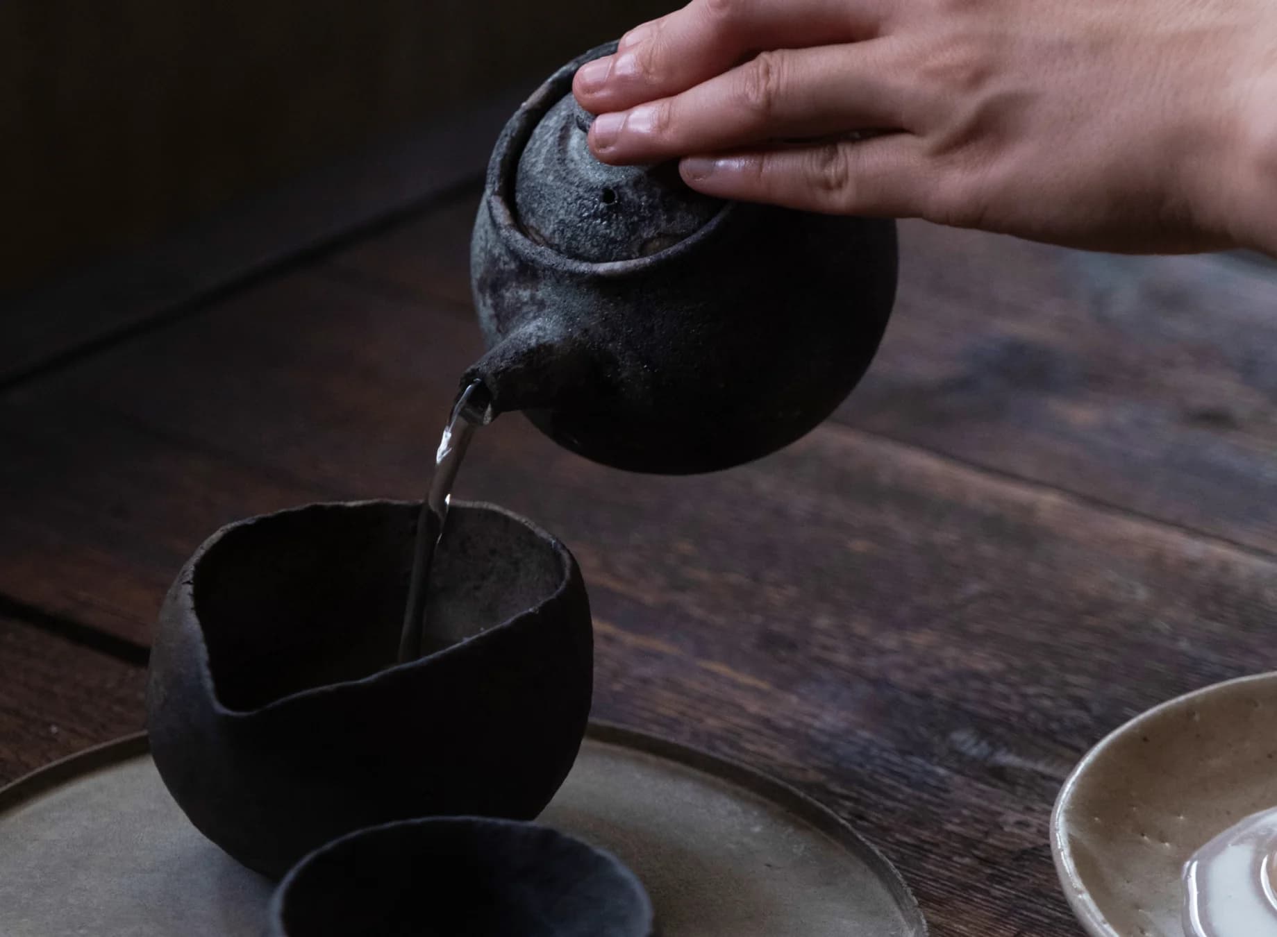 Tea being poured from a clay teapot