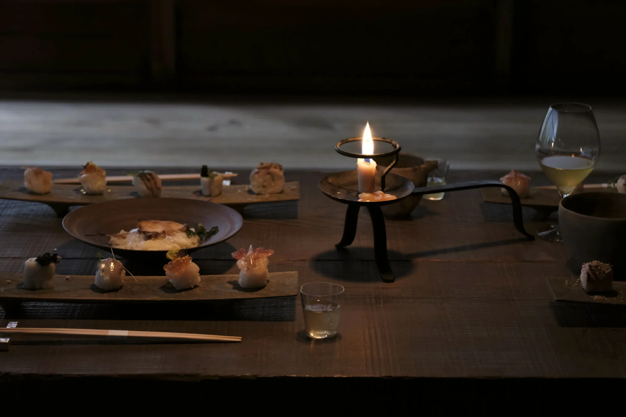 Candlelit dinner table with sushi dishes