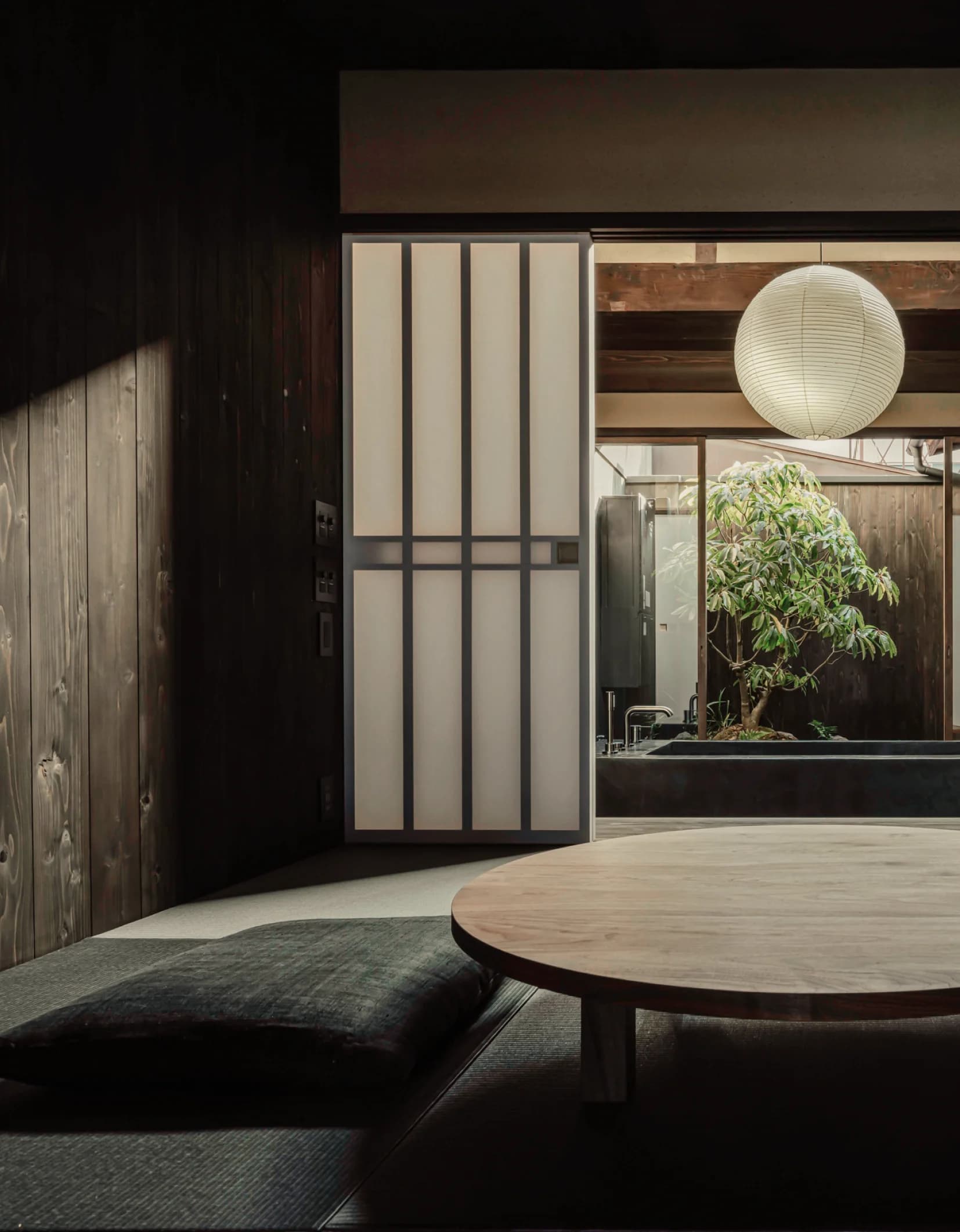 Glass sliding doors opening to a courtyard garden with stone path and greenery